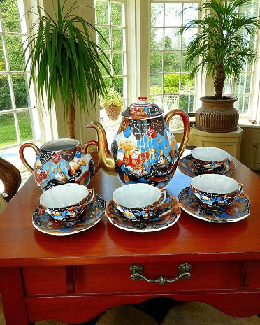 Antique Japanese hand-painted porcelain coffee set with coffee pot, sugar pot, cups, and saucers, richly decorated with figures and gilded detail.