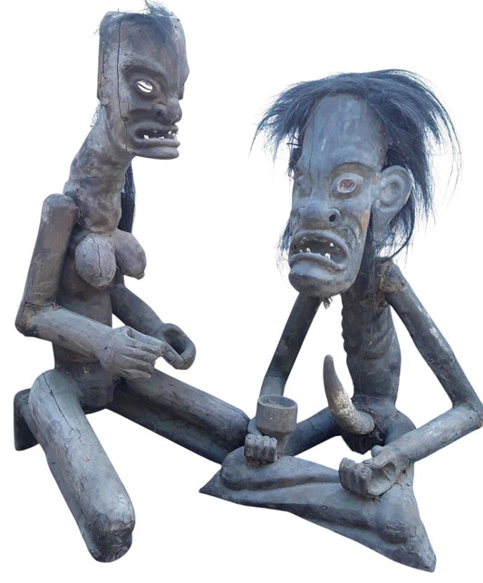 Pair of African 20th century carved wood figures with exaggerated features, shell eyes, and natural hair, male and female, in aged condition.