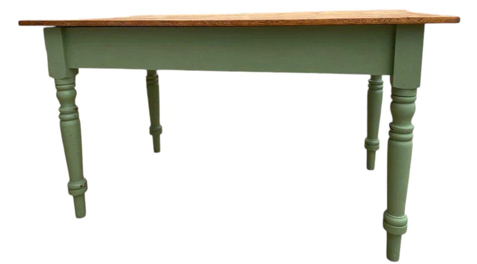 Side view of vintage farmhouse table showing turned pine legs in green paint.