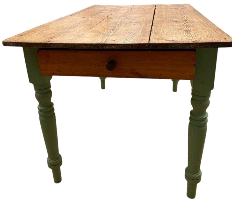 Rustic antique pine farmhouse dining table with green painted legs and open drawer.