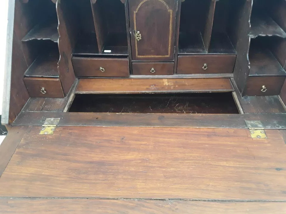 Wooden desk with open top drawer showing wear and tear