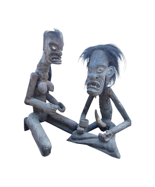 Pair of African 20th century carved wood figures with exaggerated features, shell eyes, and natural hair, male and female, in aged condition.