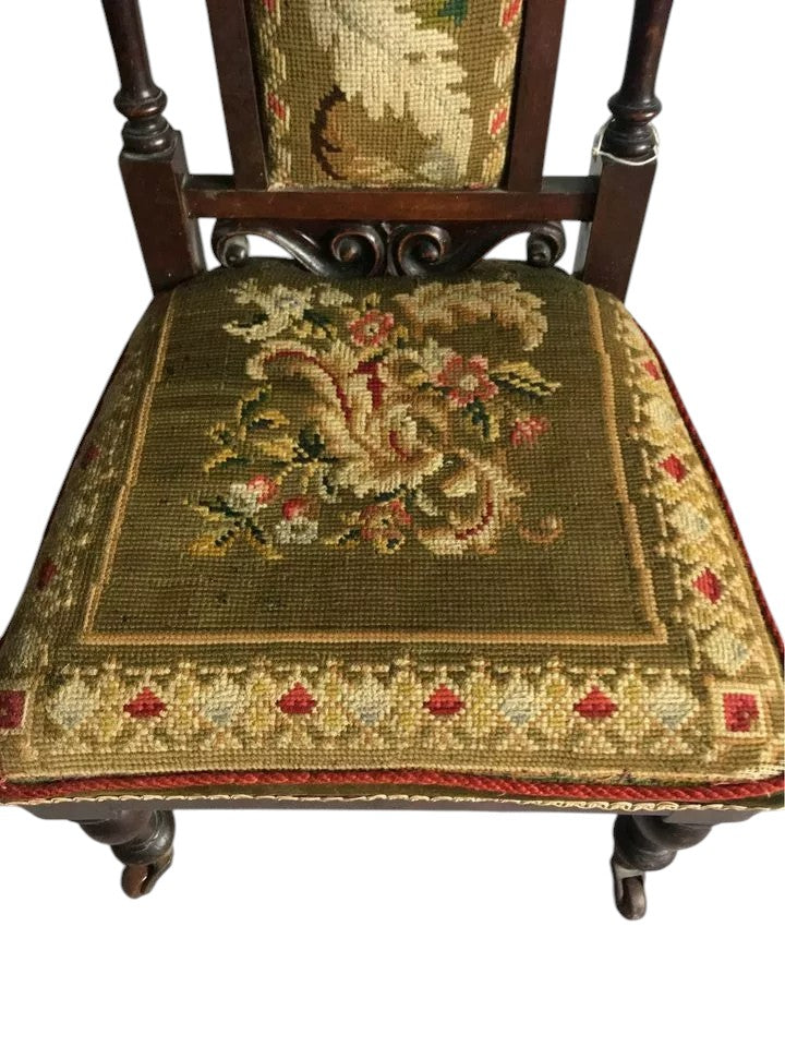 Close-up of antique Victorian chair tapestry with floral motifs.