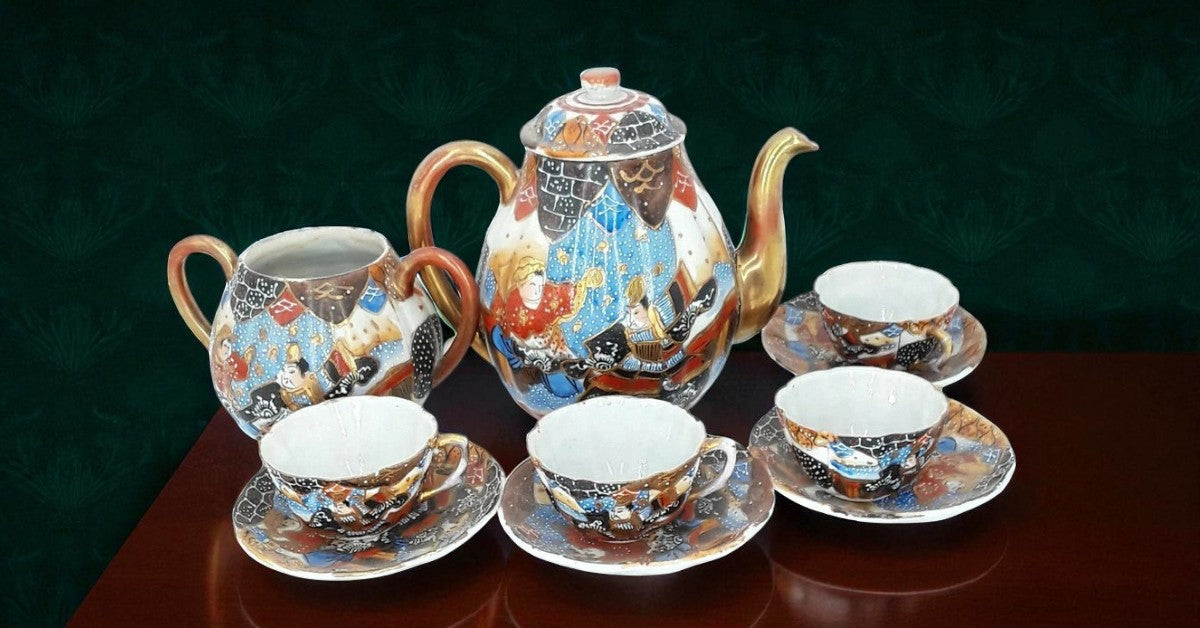 Antique Japanese hand-painted porcelain coffee set with coffee pot, sugar pot, cups, and saucers, richly decorated with figures and gilded detail.