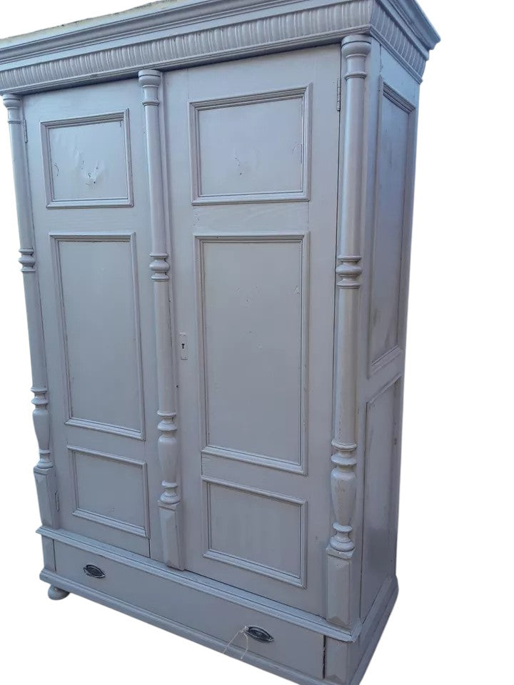 Antique pine wardrobe with two panelled doors, original lock, and large base drawer with iron handles, rustic farmhouse style.