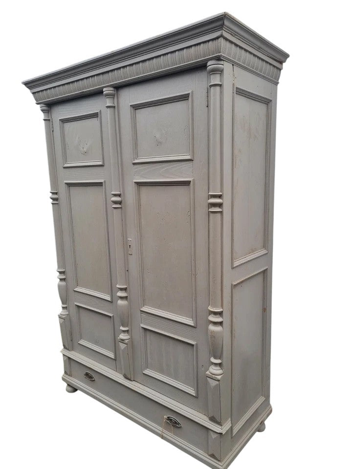 Antique pine wardrobe with two panelled doors, original lock, and large base drawer with iron handles, rustic farmhouse style.