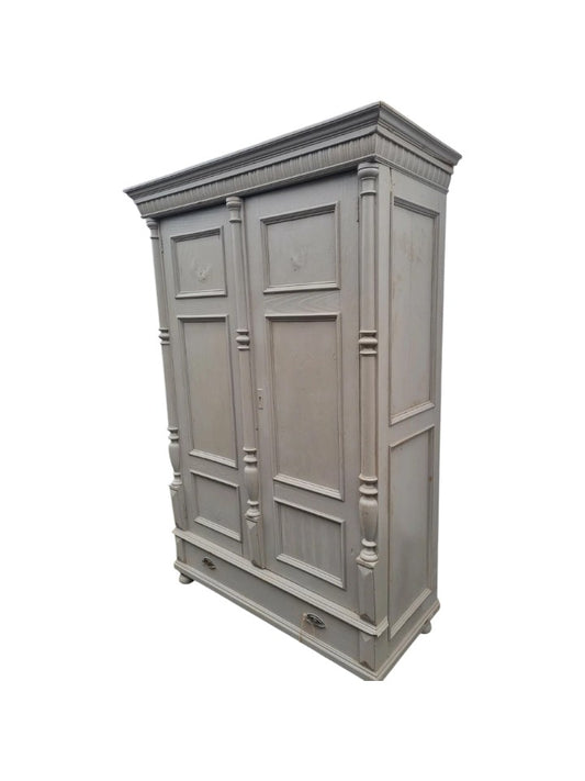 Antique pine wardrobe with two panelled doors, original lock, and large base drawer with iron handles, rustic farmhouse style.